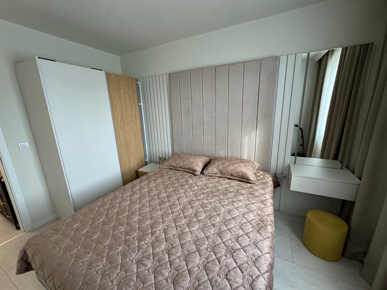 Современная спальня с двумя кроватями, стильным зеркалом и уютным освещением, идеально подходит для продажи недвижимости в Болгарии.