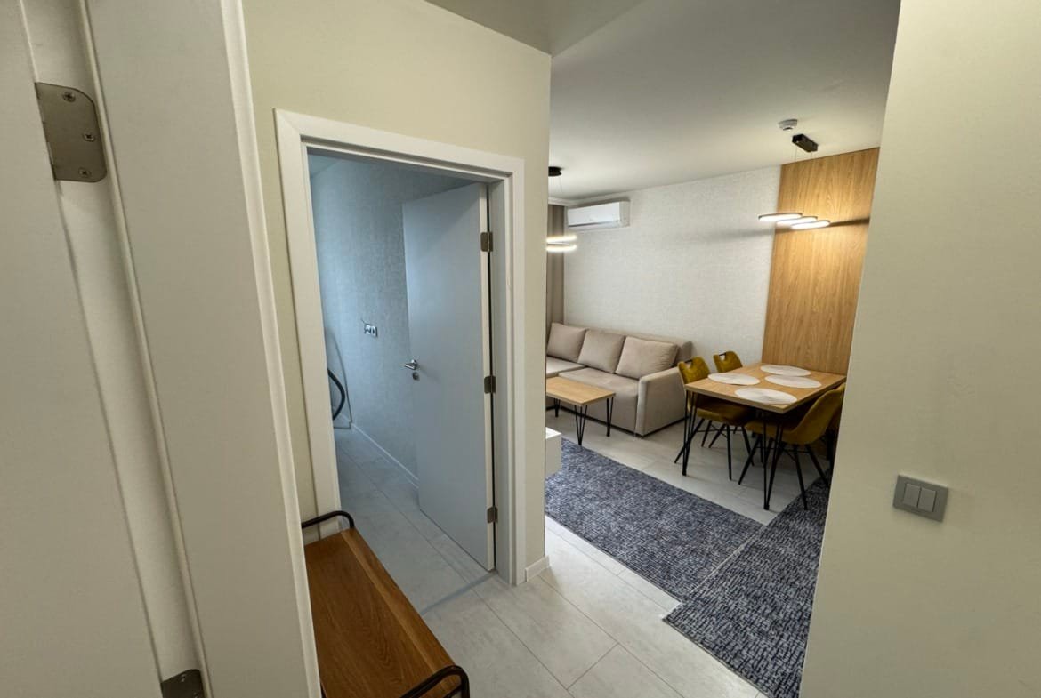 Современный интерьер квартиры в Болгарии с просторной гостиной, столовой зоной и светлыми тонами отделки.