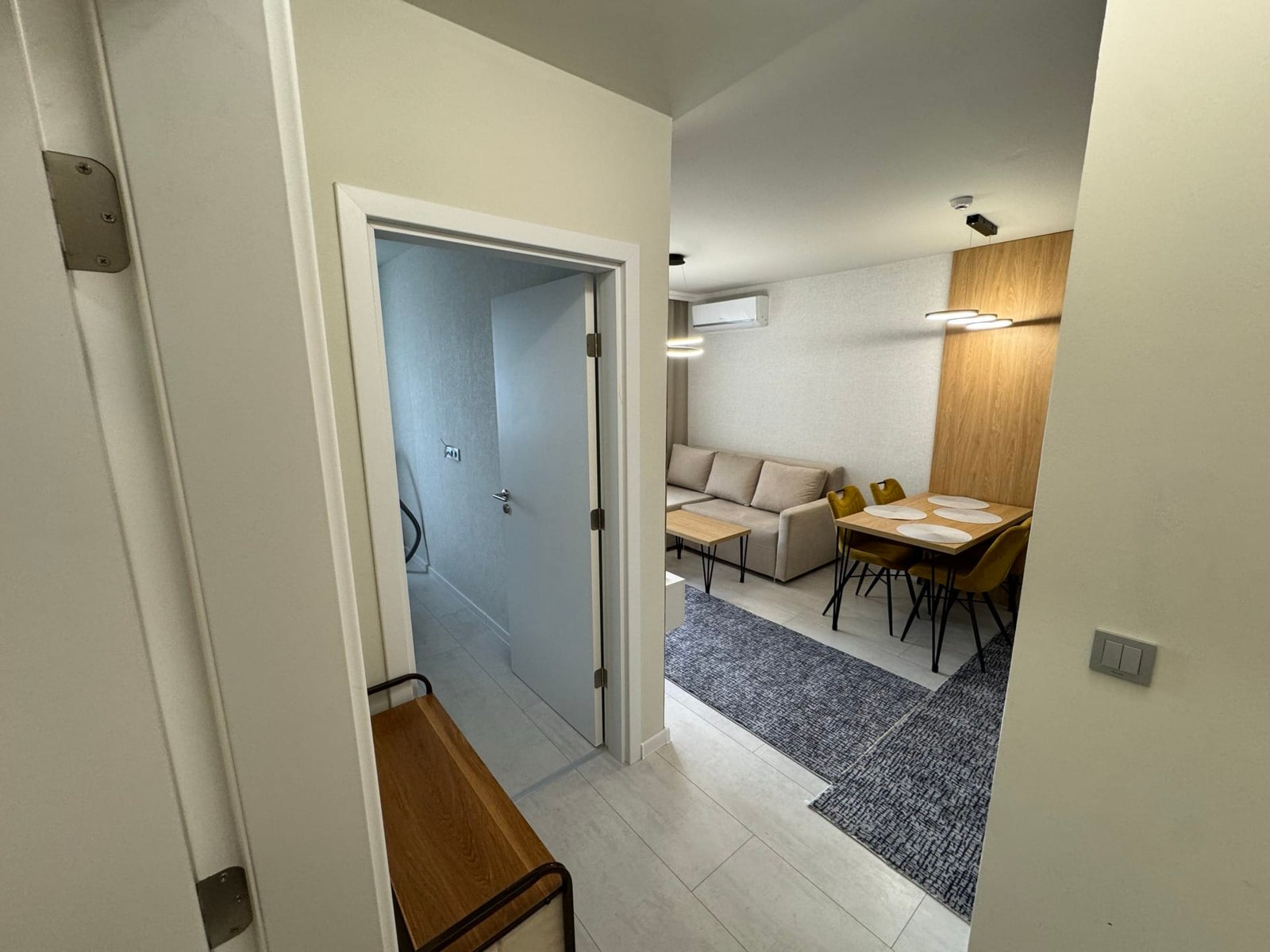 Современный интерьер квартиры в Болгарии с просторной гостиной, столовой зоной и светлыми тонами отделки.