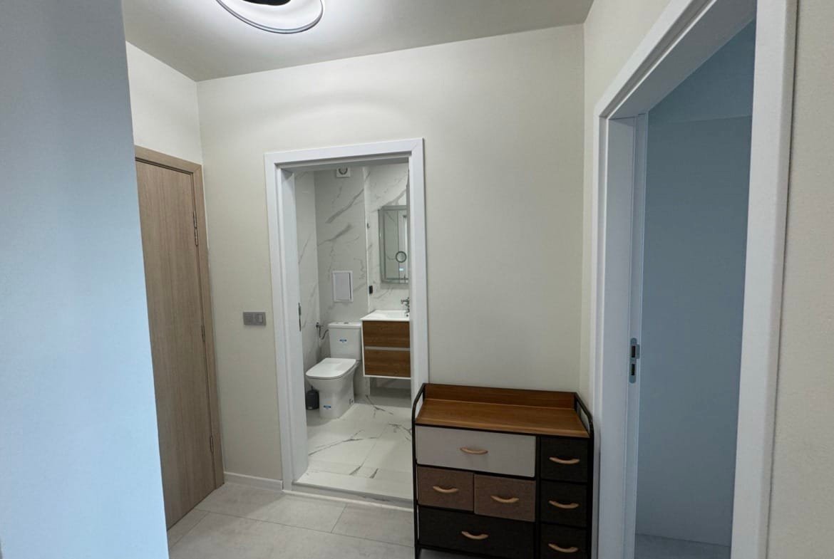 Современный коридор с ванной, светлым интерьером и комодом, подходящий для продажи недвижимости в Болгарии.