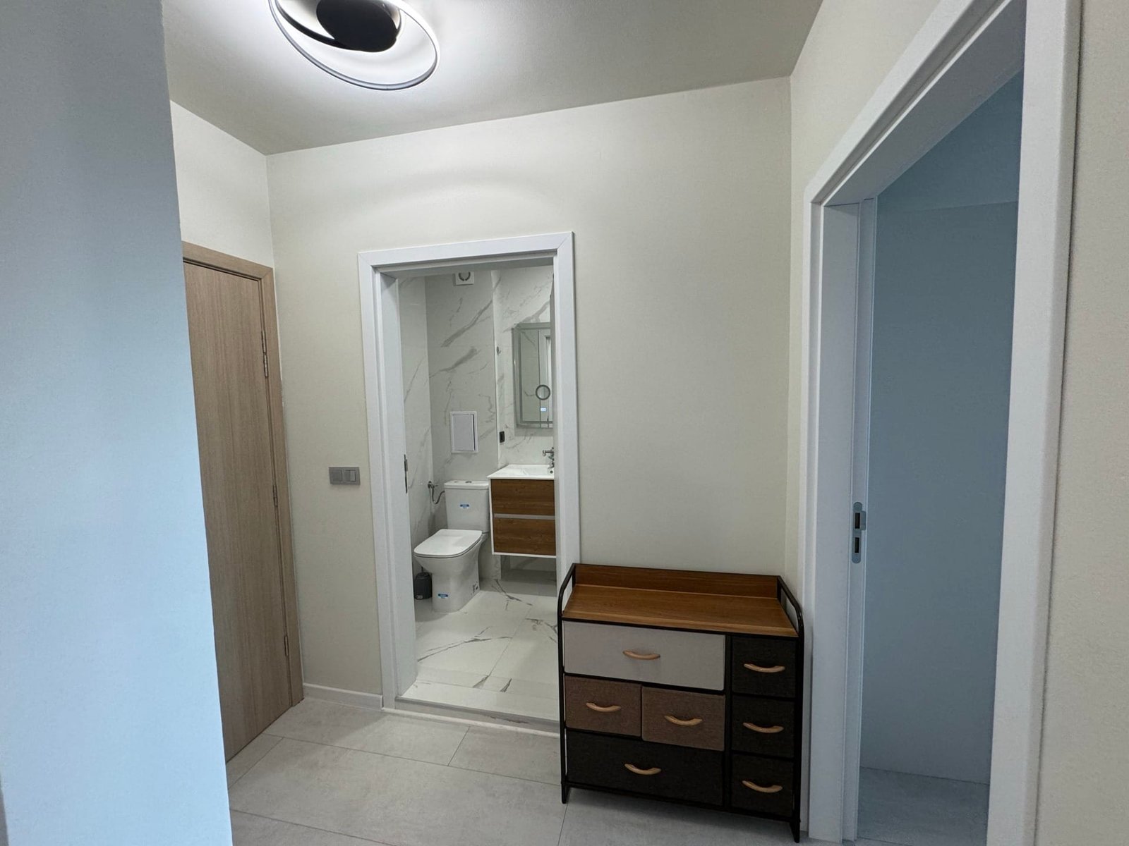 Современный коридор с ванной, светлым интерьером и комодом, подходящий для продажи недвижимости в Болгарии.