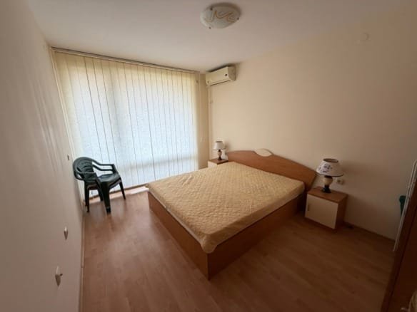 Светлая квартира в Болгарии, уютная спальня с двуспальной кроватью и кондиционером, стильный интерьер.