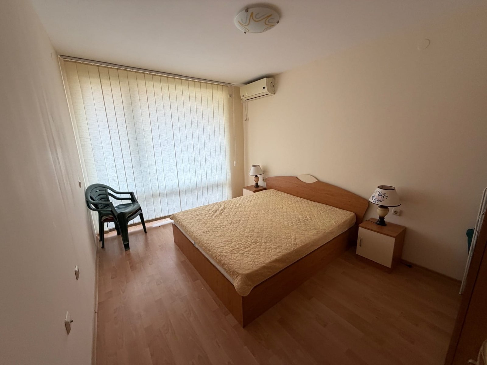 Светлая квартира в Болгарии, уютная спальня с двуспальной кроватью и кондиционером, стильный интерьер.