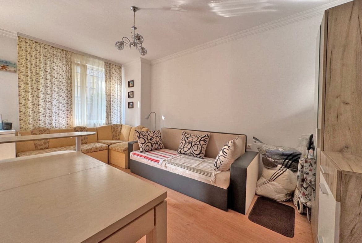 Современная гостиная с диваном и уютными мягкими креслами, расположенная в квартире для продажи, предлагает комфорт и светлое пространство.