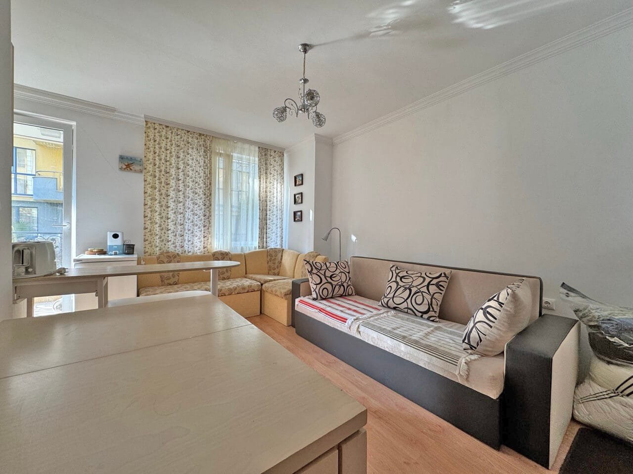 Светлая гостиная с диваном и удобными креслами, идеальное жилье для покупки в Болгарии, рядом с апартаментами у моря.