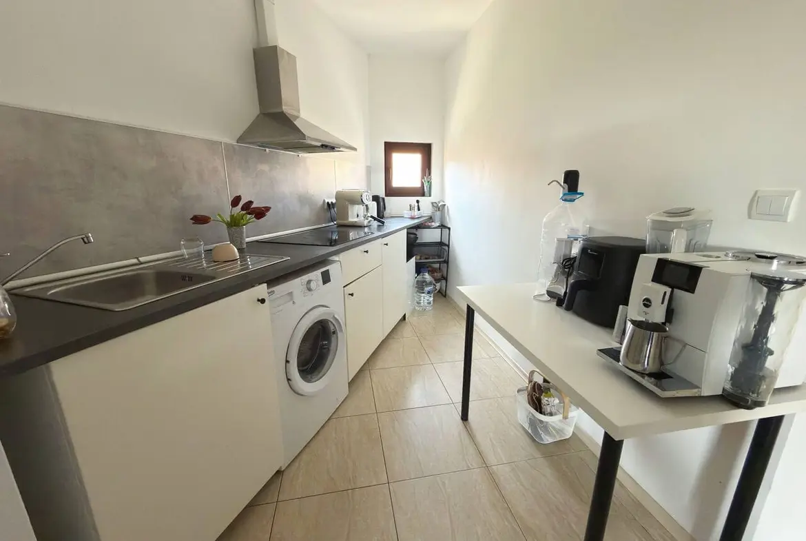 Светлая кухня с современными приборами, стиральной машиной и кофемашиной, идеальна для апартаментов у моря в Болгарии.