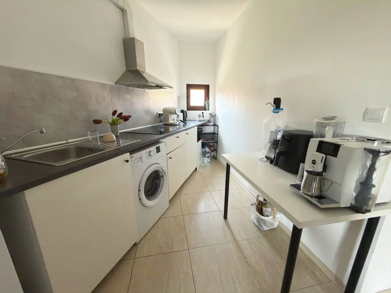 Светлая кухня с современными приборами, стиральной машиной и кофемашиной, идеальна для апартаментов у моря в Болгарии.