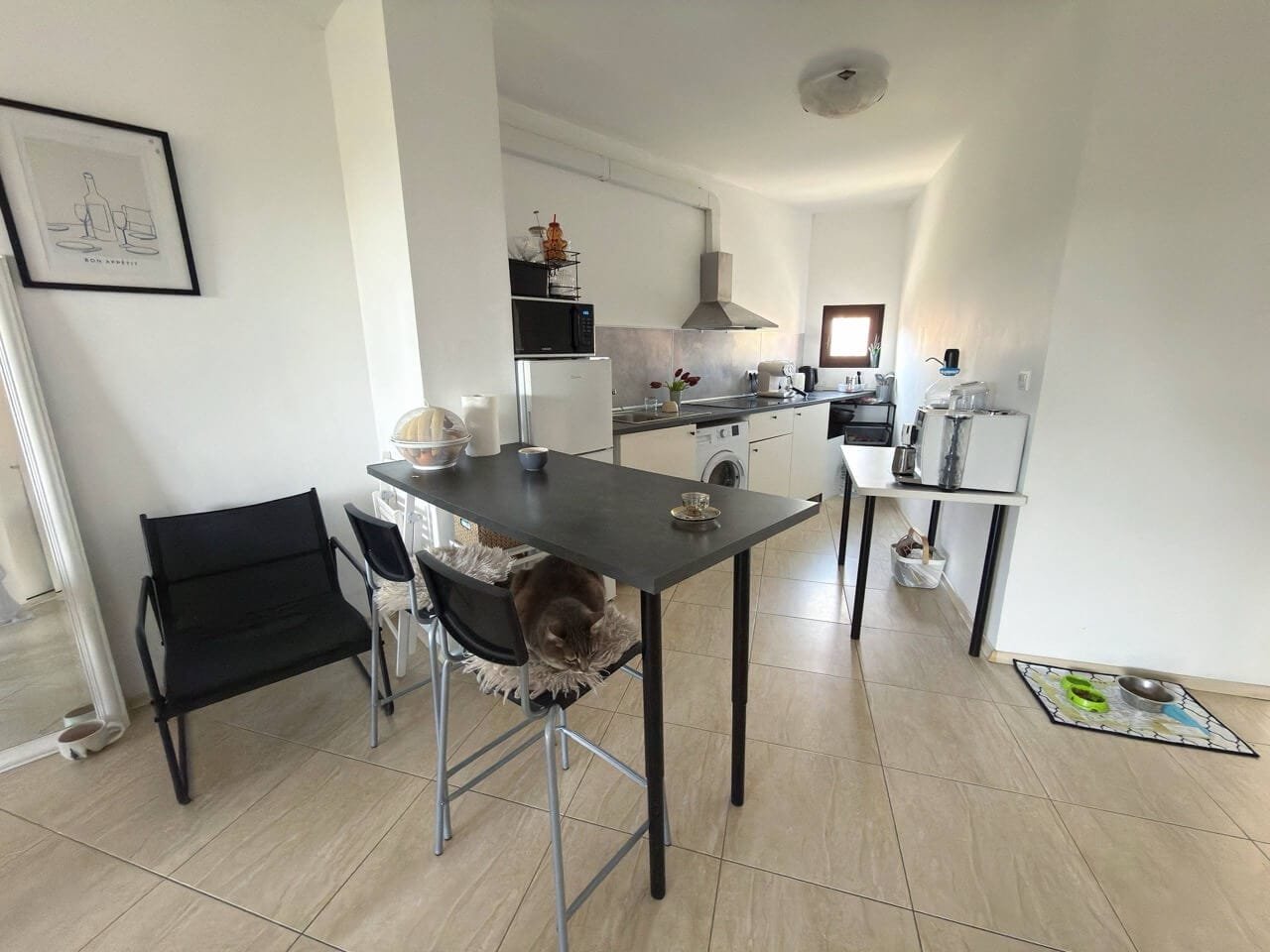 Современная кухня с обеденным столом и бытовой техникой Современная кухня с обеденным столом и стульями, светлое пространство, идеальное жилье для апартаментов в Болгарии.