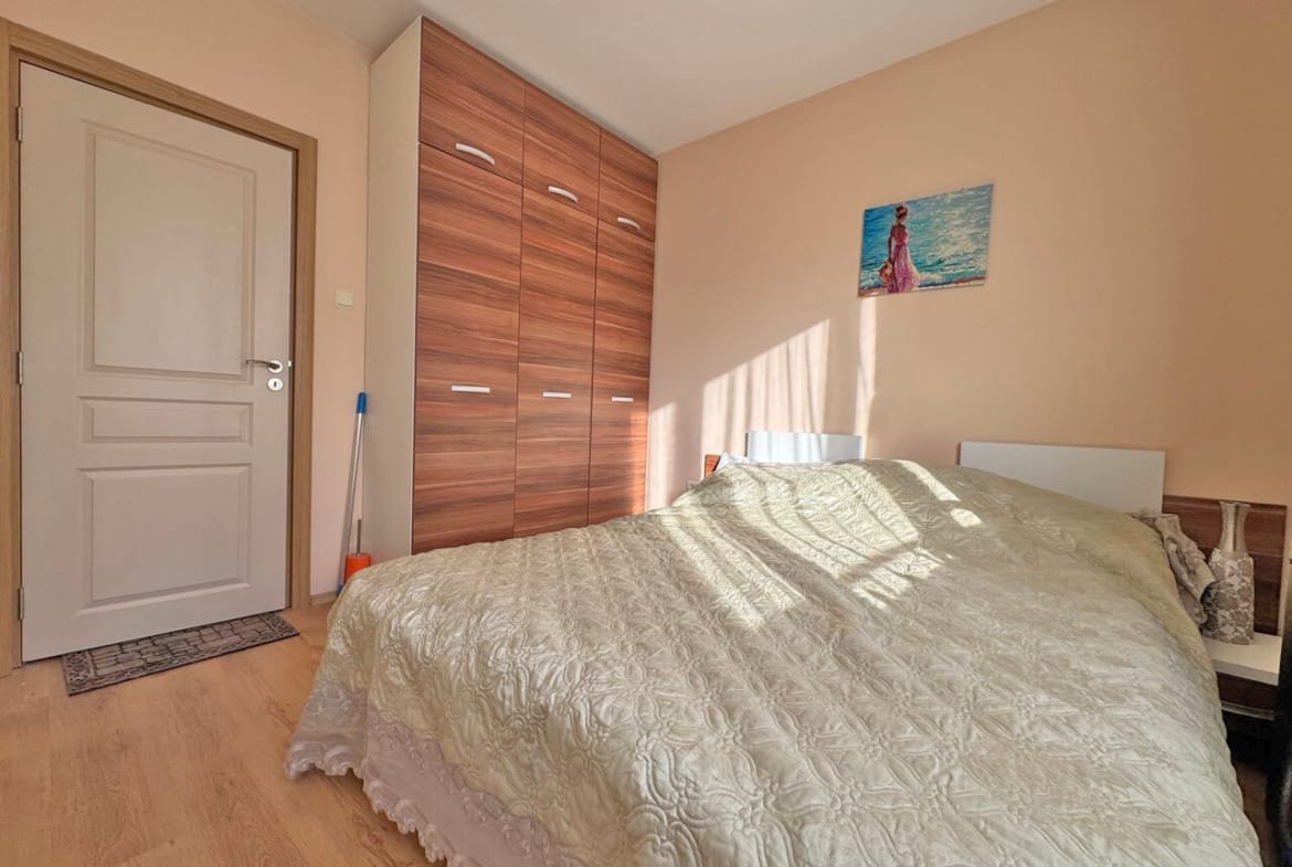 Спальня с двуспальной кроватью, шкафом и светлыми стенами, идеальная для жилья на Солнечном берегу, Болгария.