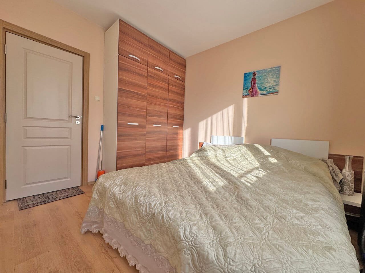 Спальня с двуспальной кроватью, шкафом и светлыми стенами, идеальная для жилья на Солнечном берегу, Болгария.