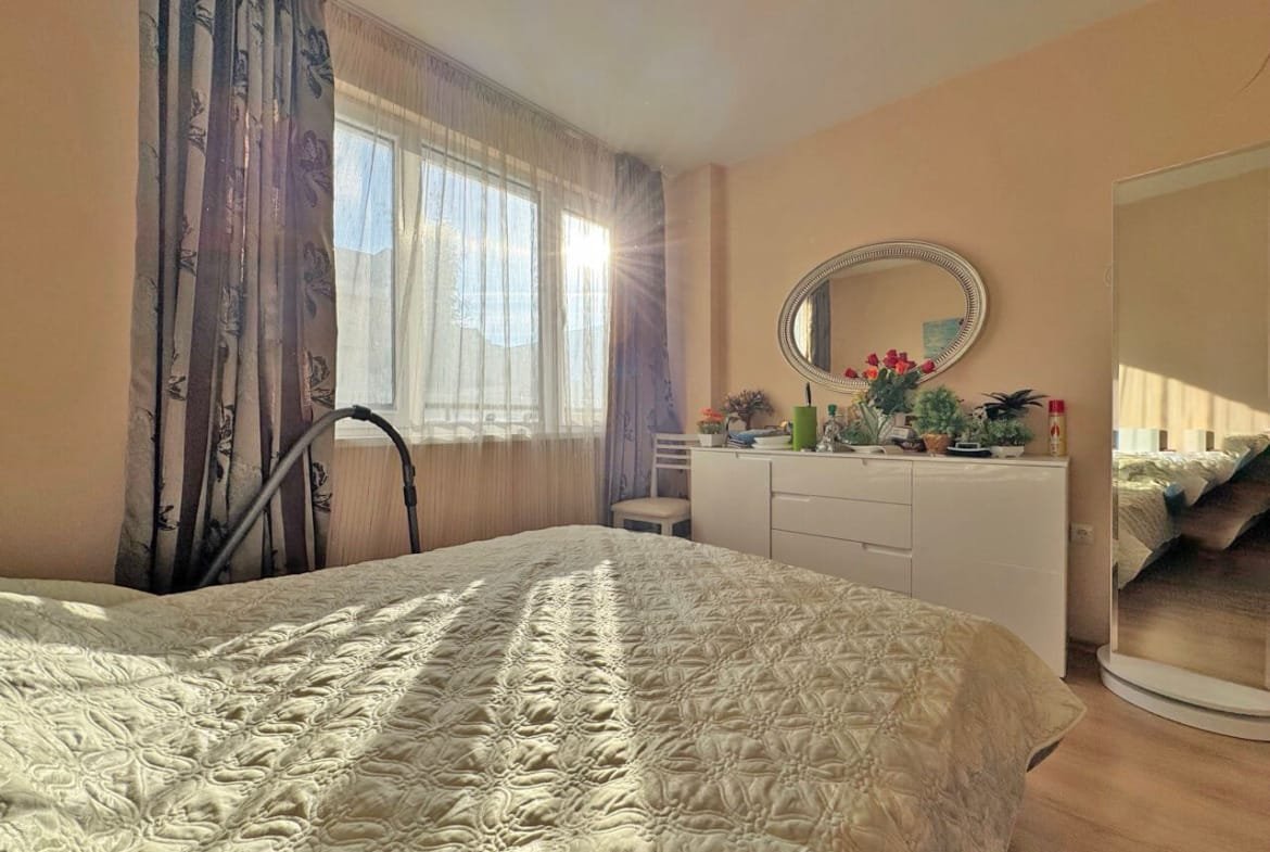 Светлая спальня с окнами на юг, современная мебель, уютная атмосфера, идеальна для отдыха в квартире в Болгарии.