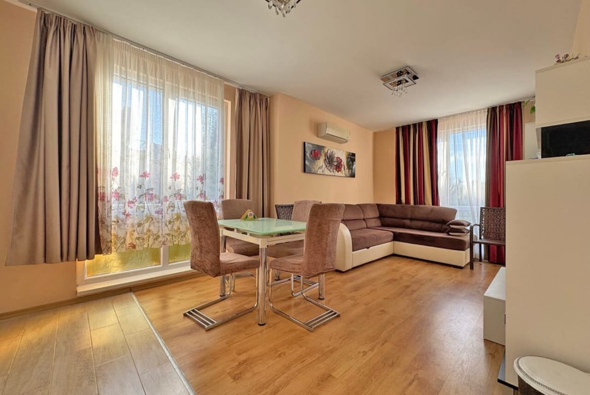 Современная гостиная с большим угловым диваном, обеденной зоной и светлыми занавесками, расположенная в квартире в Святом Власе.