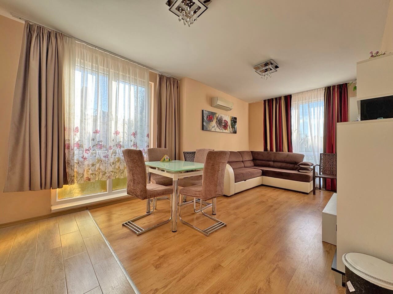 Современная гостиная с большим угловым диваном, обеденной зоной и светлыми занавесками, расположенная в квартире в Святом Власе.