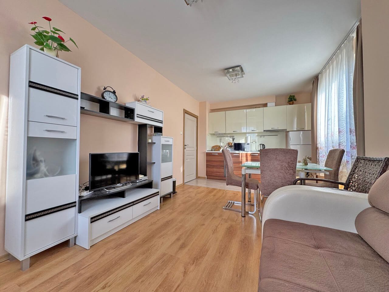 Современная гостиная с мягкой мебелью, телевизором и столовой зоной, отлично подходящая для квартиры в Святом Власе.