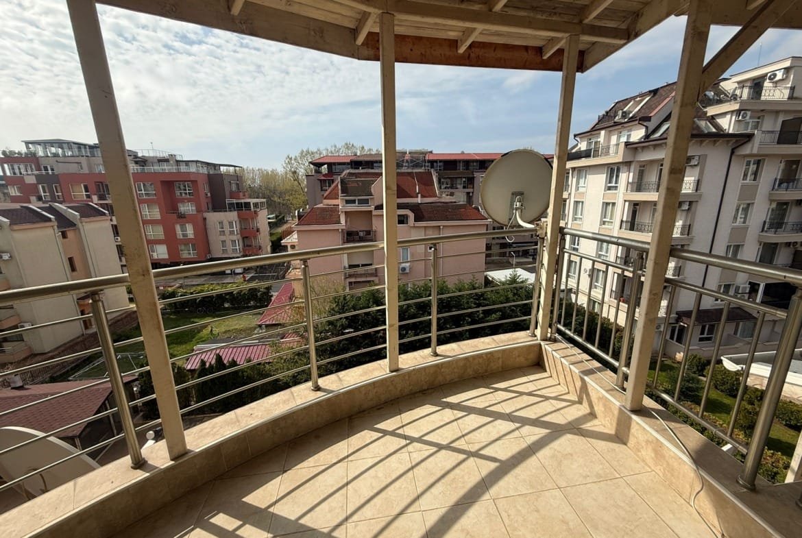 Балкон с видом на жилые здания и зеленую территорию в Болгарии, идеальное место для проживания и инвестиций в недвижимость.