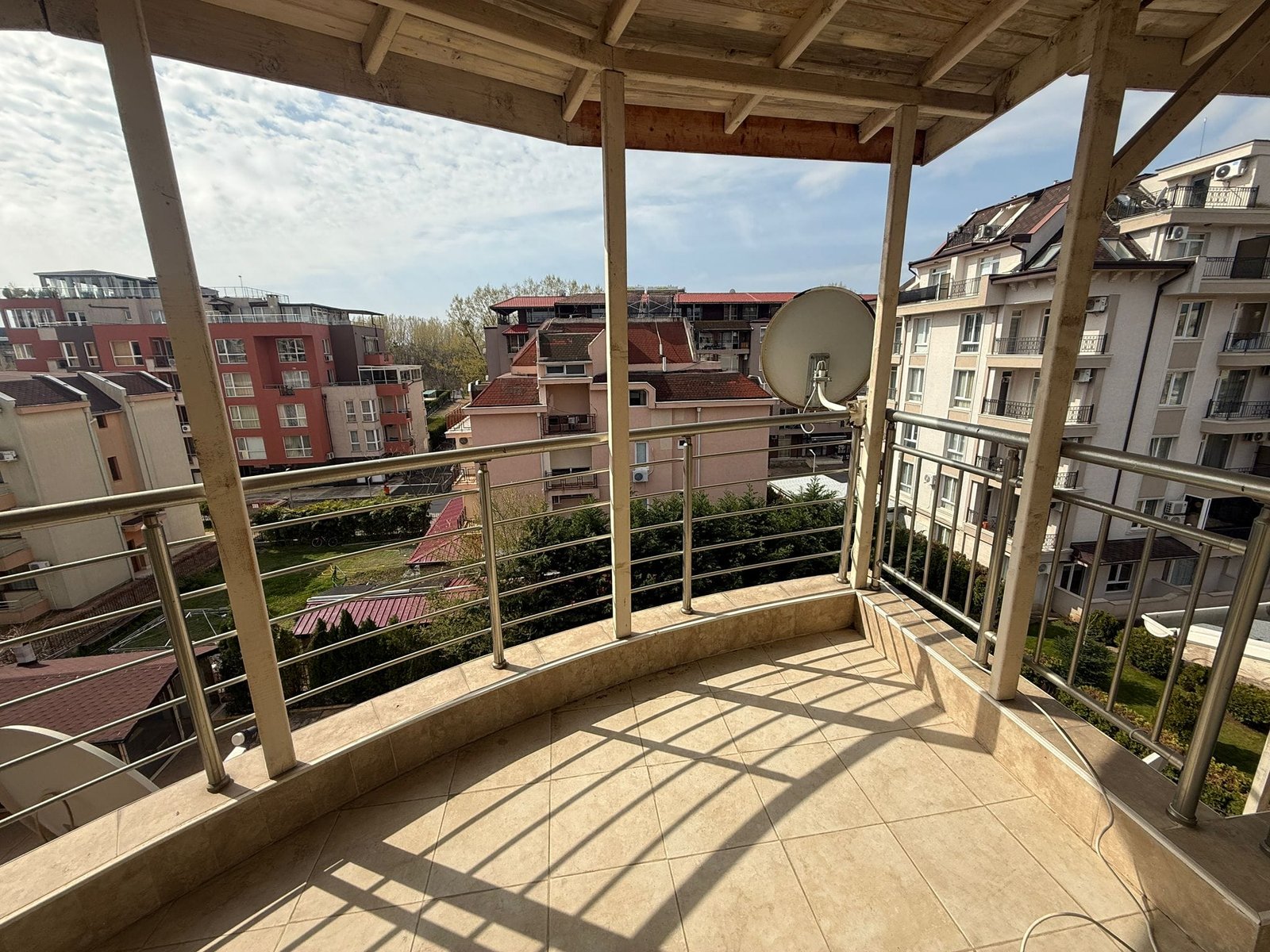 Балкон с видом на жилые здания и зеленую территорию в Болгарии, идеальное место для проживания и инвестиций в недвижимость.