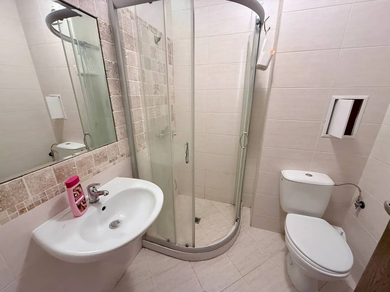 Современная ванная комната с душевой кабиной и раковиной Современная ванная комната с душевой кабиной, раковиной и туалетом, оформленная в светлых тонах, идеально для жилья в Болгарии.