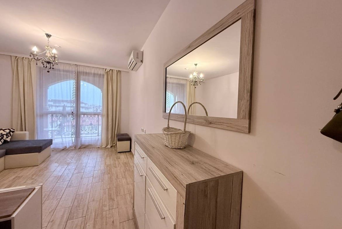 Современный интерьер квартиры в Болгарии с белыми стенами, деревянной мебелью и ярким освещением, идеально подходит для жизни или аренды.