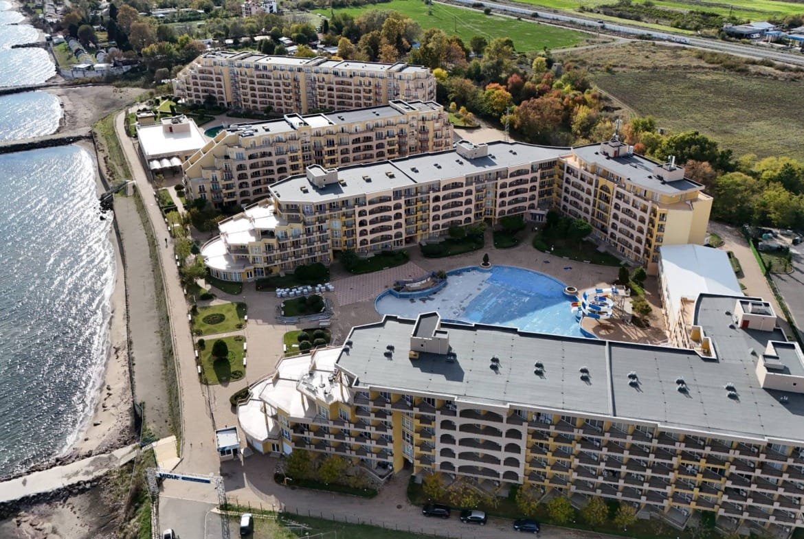 Комплекс “Midia Family Resort” с бассейном, зелеными насаждениями и видом на море, расположенный рядом с пляжем.
