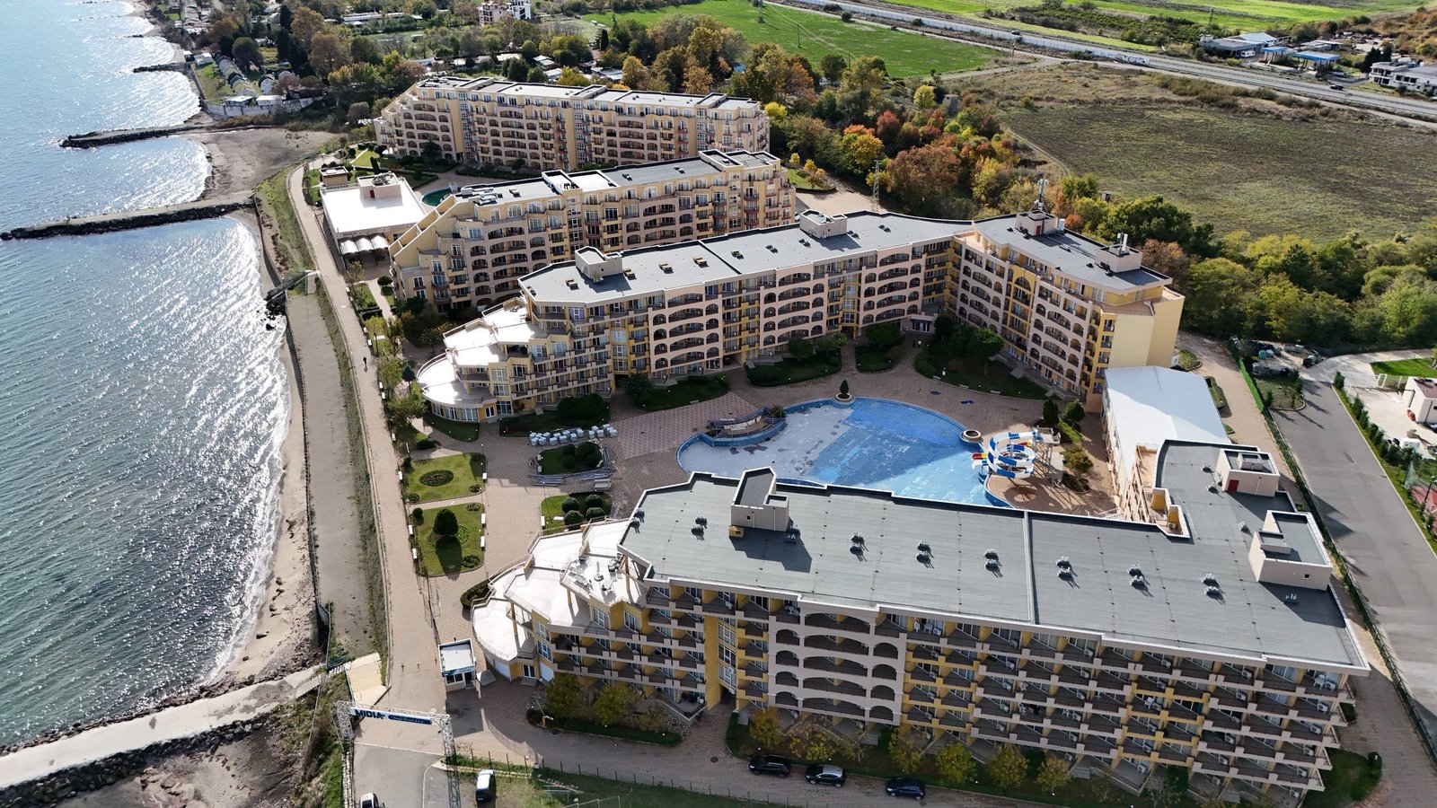 Комплекс “Midia Family Resort” с бассейном, зелеными насаждениями и видом на море, расположенный рядом с пляжем.