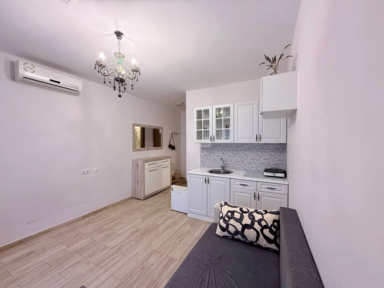 Современная кухня-студия с уютным интерьером и светлыми тонами Современная квартира с кухонным гарнитуром, светлым интерьером и уютной зоной для отдыха в Болгарии. Отличный вариант для покупки.