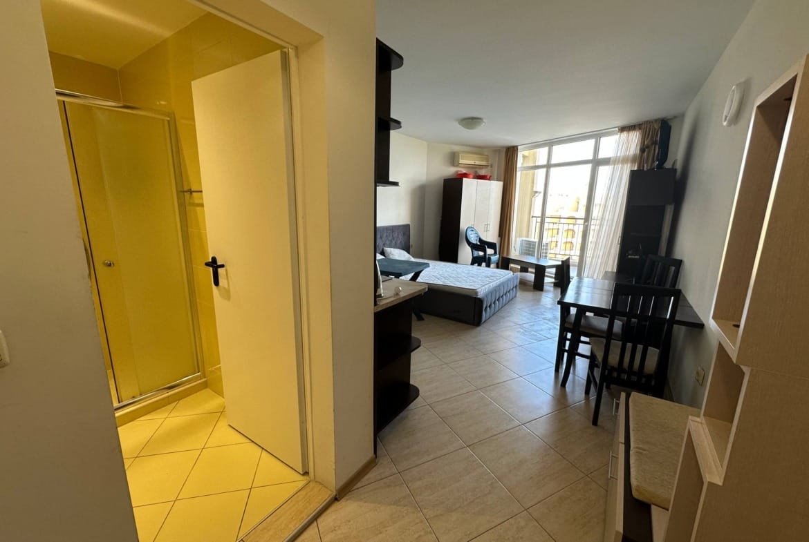 Современная студия с открытой планировкой, кухонным уголком, обеденной зоной и ванной, много света и простор.