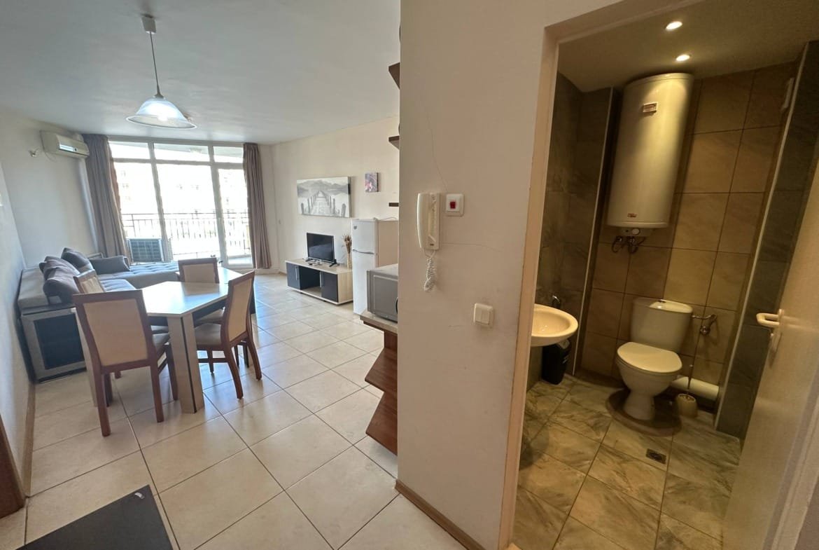 Современная квартира с кухней, обеденной зоной, гостиной и ванной комнатой, светлые тона и уютная обстановка.