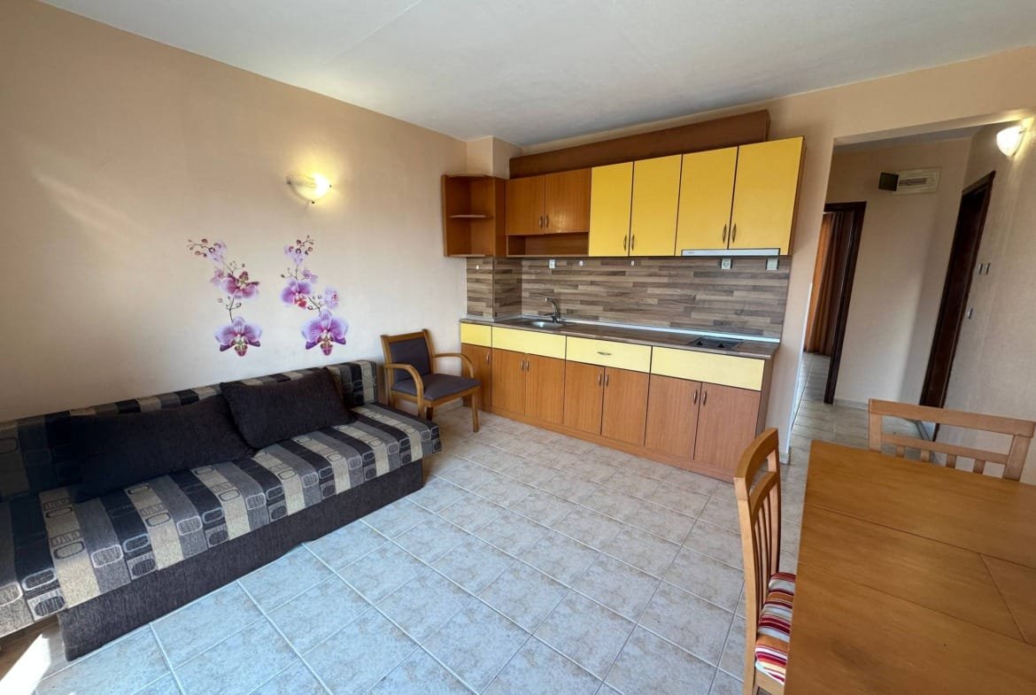 Современный двухкомнатный апартамент в комплексе с кухней, обеденной зоной и уютным диваном, оформленный в светлых тонах.