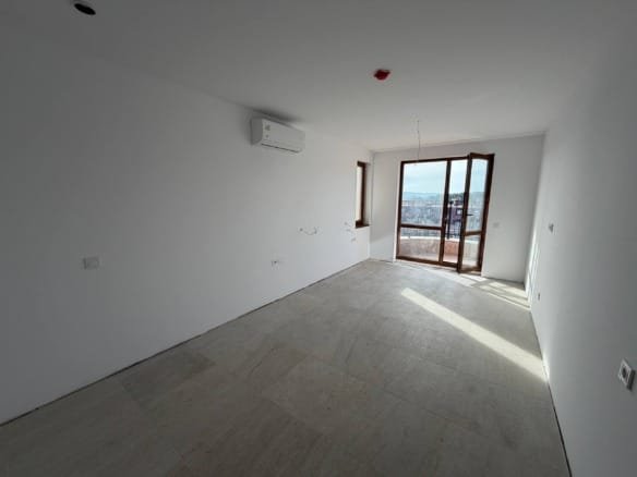 Просторная студия с большими окнами и видом, свежий ремонт, плиточный пол, кондиционер на стене.