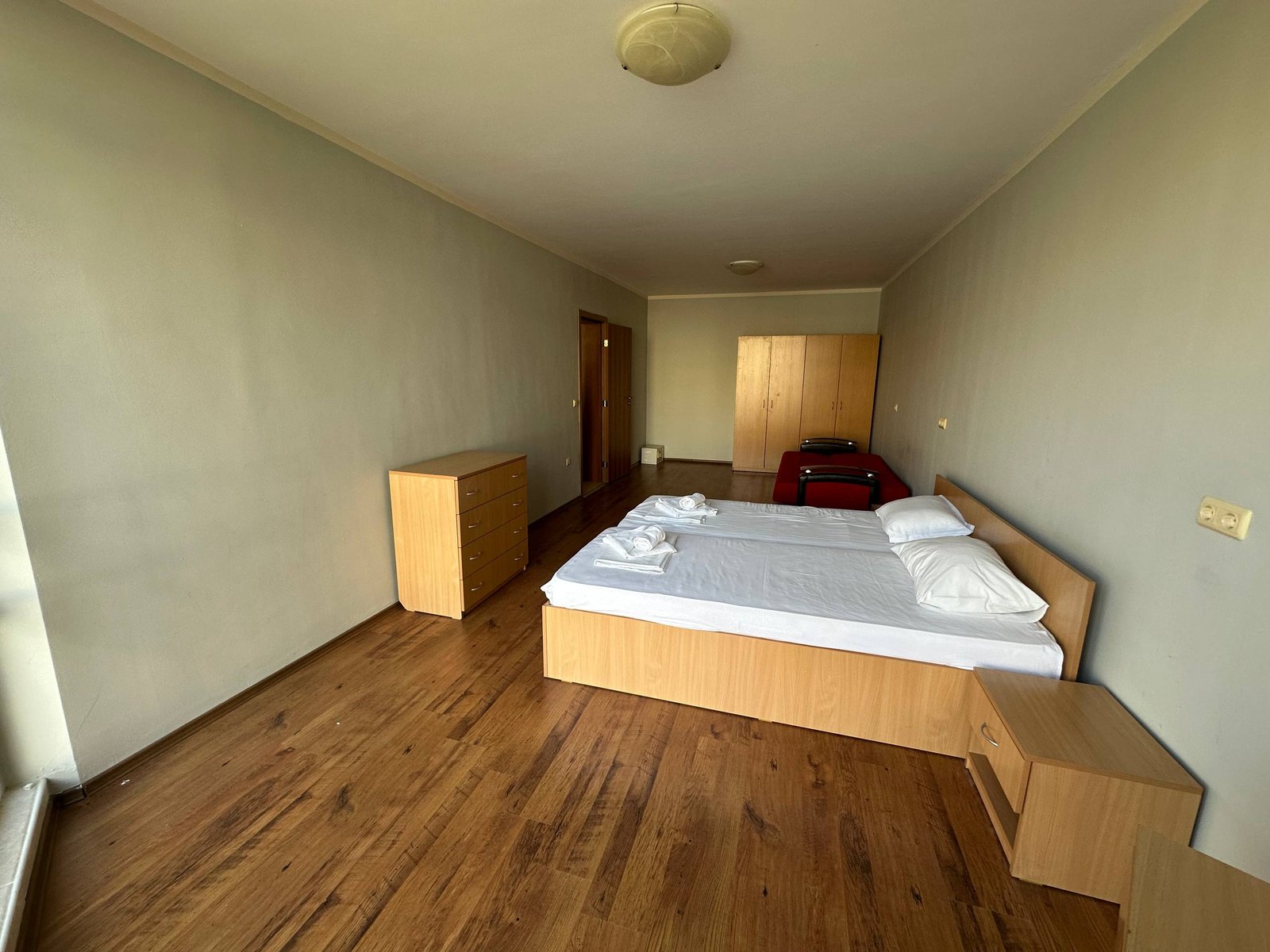 photo_7_2025-12-09_19-10-27 Современная комната с двумя односпальными кроватями, деревянной мебелью и светлыми стенами.