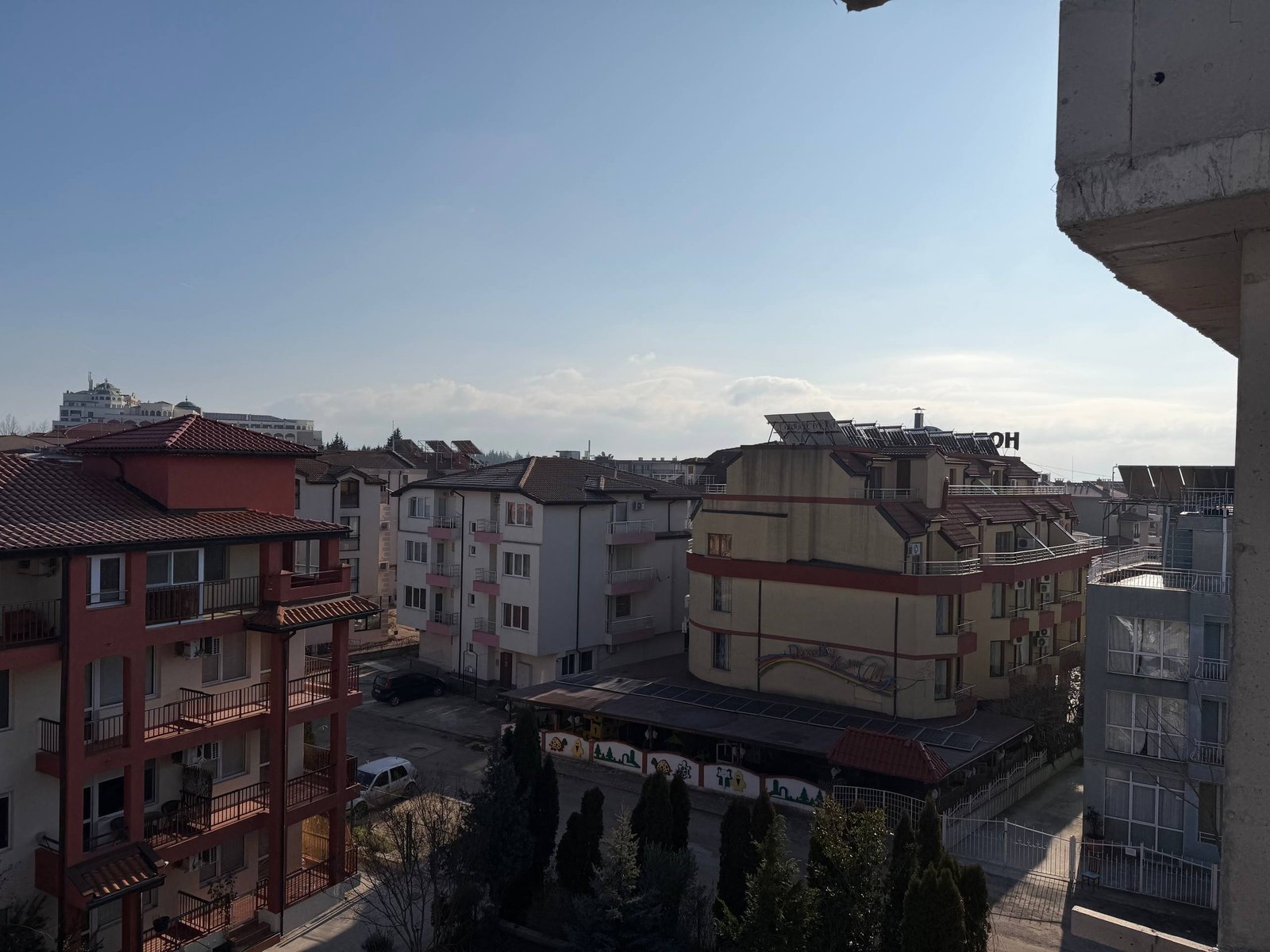 Вид на жилые здания комплекса La Mer Gold, чистое небо, яркий солнечный день, уютная атмосфера.