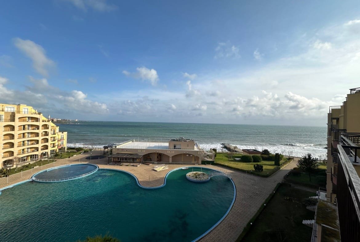 Вид на море и бассейн комплекса Midia Family Resort, окруженный зелеными насаждениями и зданиями на побережье.