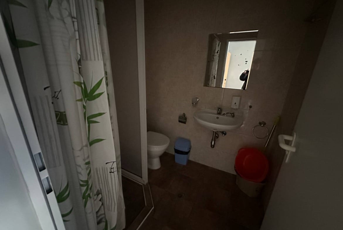 Современный санузел с душевой кабиной, умывальником и туалетом, оформленный в светлых тонах.