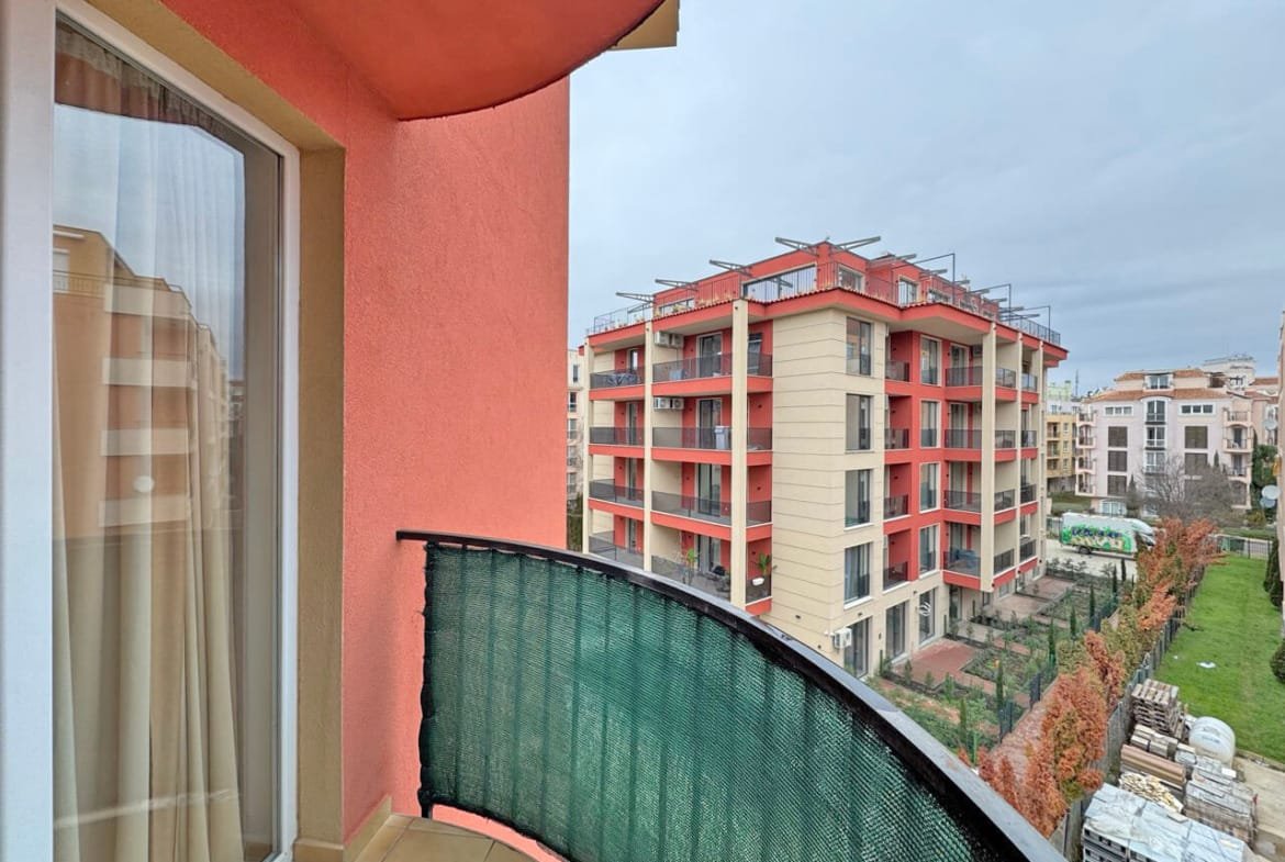 Балкон с зеленым ограждением и видом на жилой комплекс в Святом Власе, недалеко от моря и пляжа.