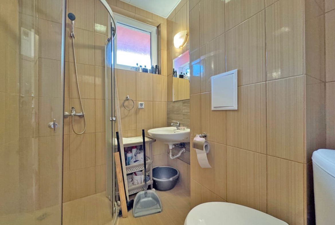 Современная ванная комната с душевой кабиной и стильной сантехникой, идеальна для апартаментов у моря в Болгарии.