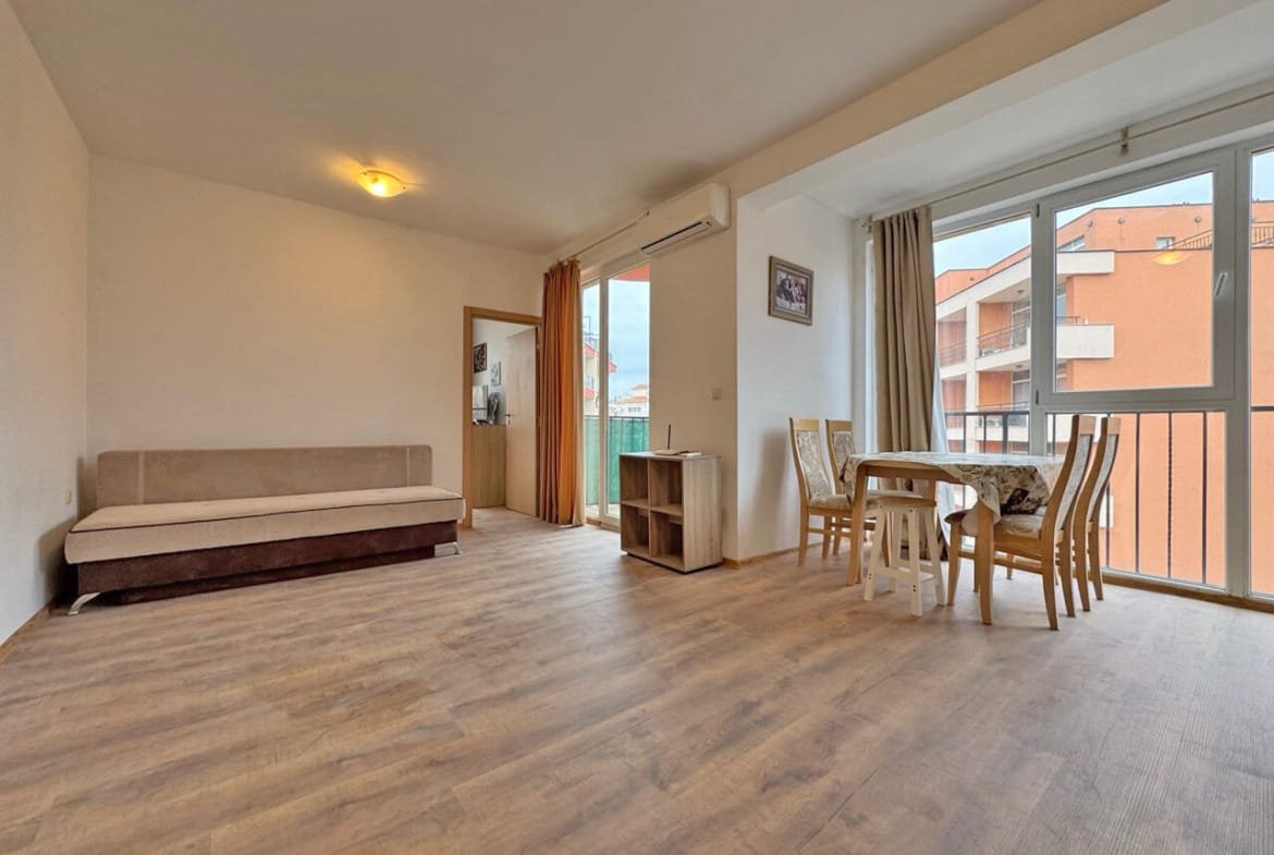 Светлая гостиная с выходом на балкон, стол и стулья, идеальная для отдыха, квартира в Святом Власе у моря.