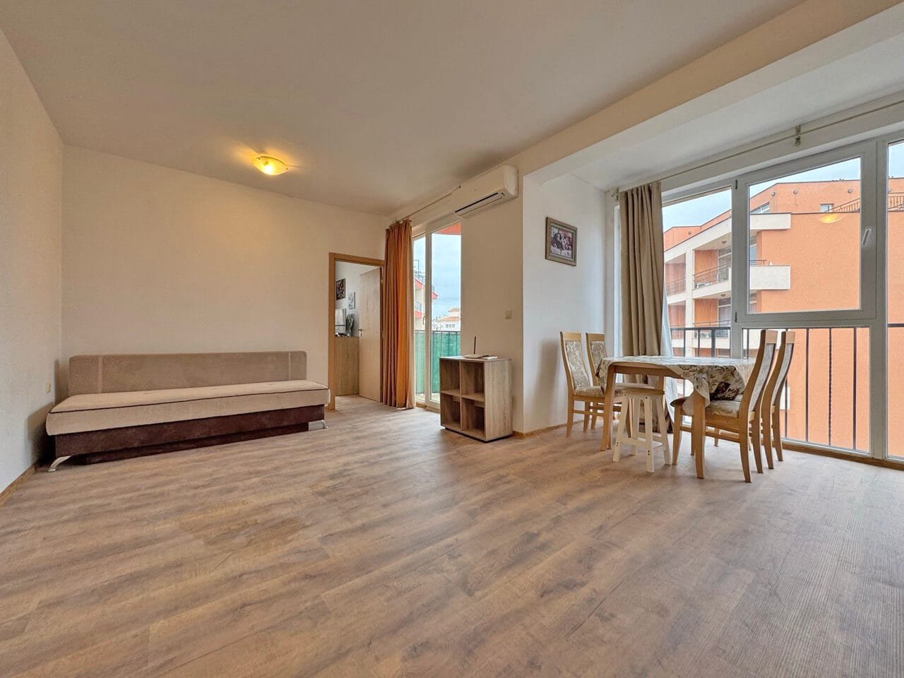 Светлая гостиная с выходом на балкон, стол и стулья, идеальная для отдыха, квартира в Святом Власе у моря.