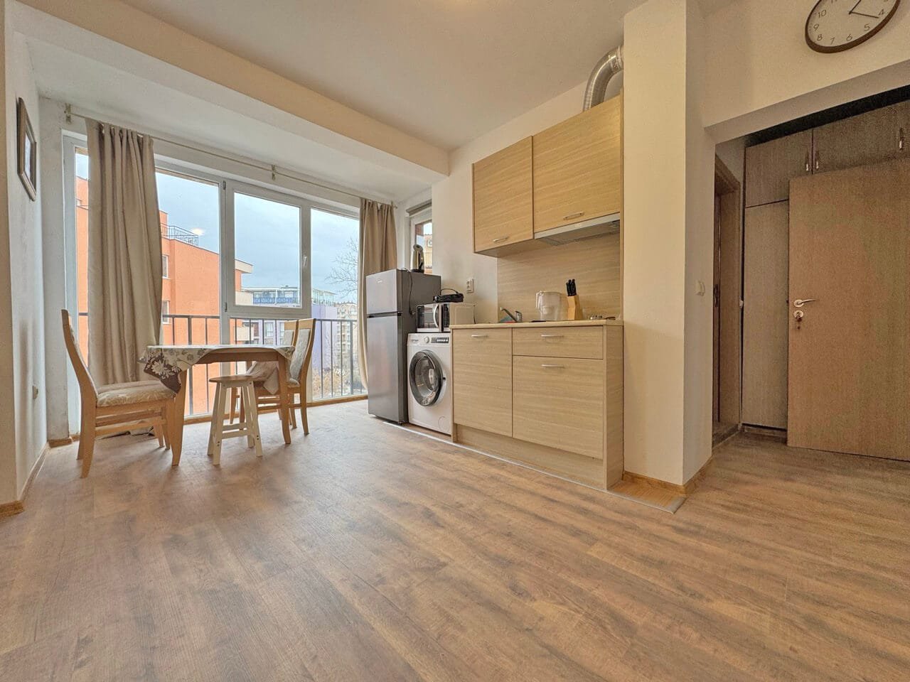 Современная кухня-гостиная в квартире в Святом Власе, светлые тона, встраиваемая техника, вид на улицу.