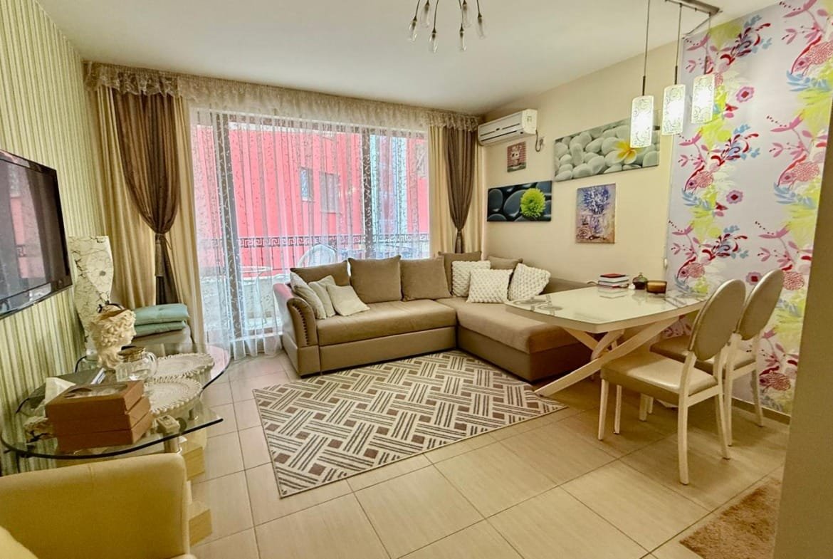 Современный уютный интерьер квартиры в Болгарии с мягкой мебелью, обеденной зоной и яркими акцентами на стенах.