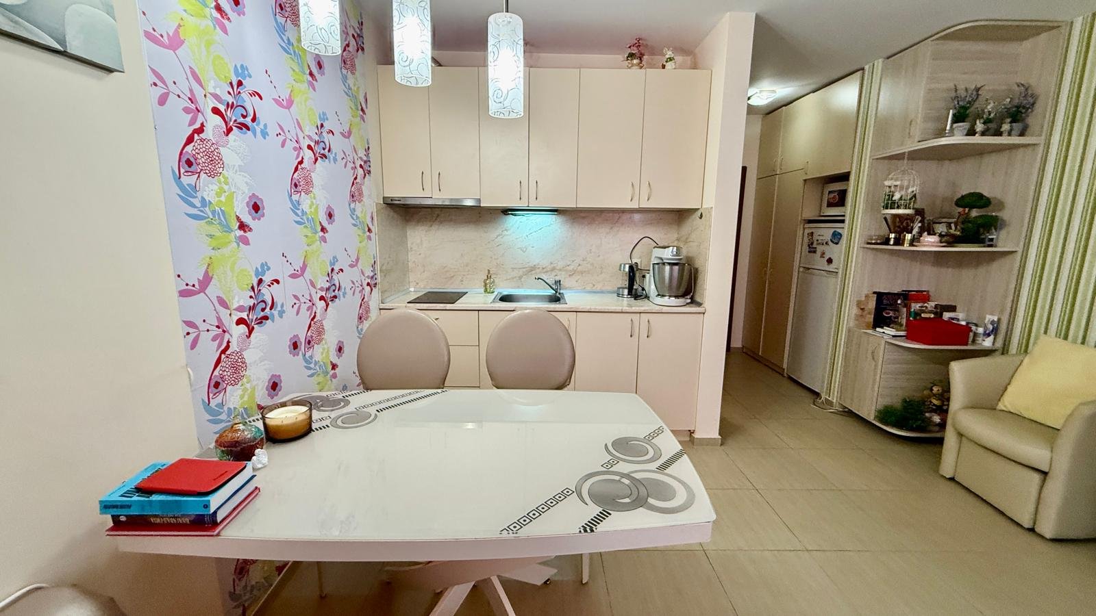 Современная кухня с обеденным столом, яркими обоями и бытовой техникой, идеальная для комфортного проживания в Болгарии.