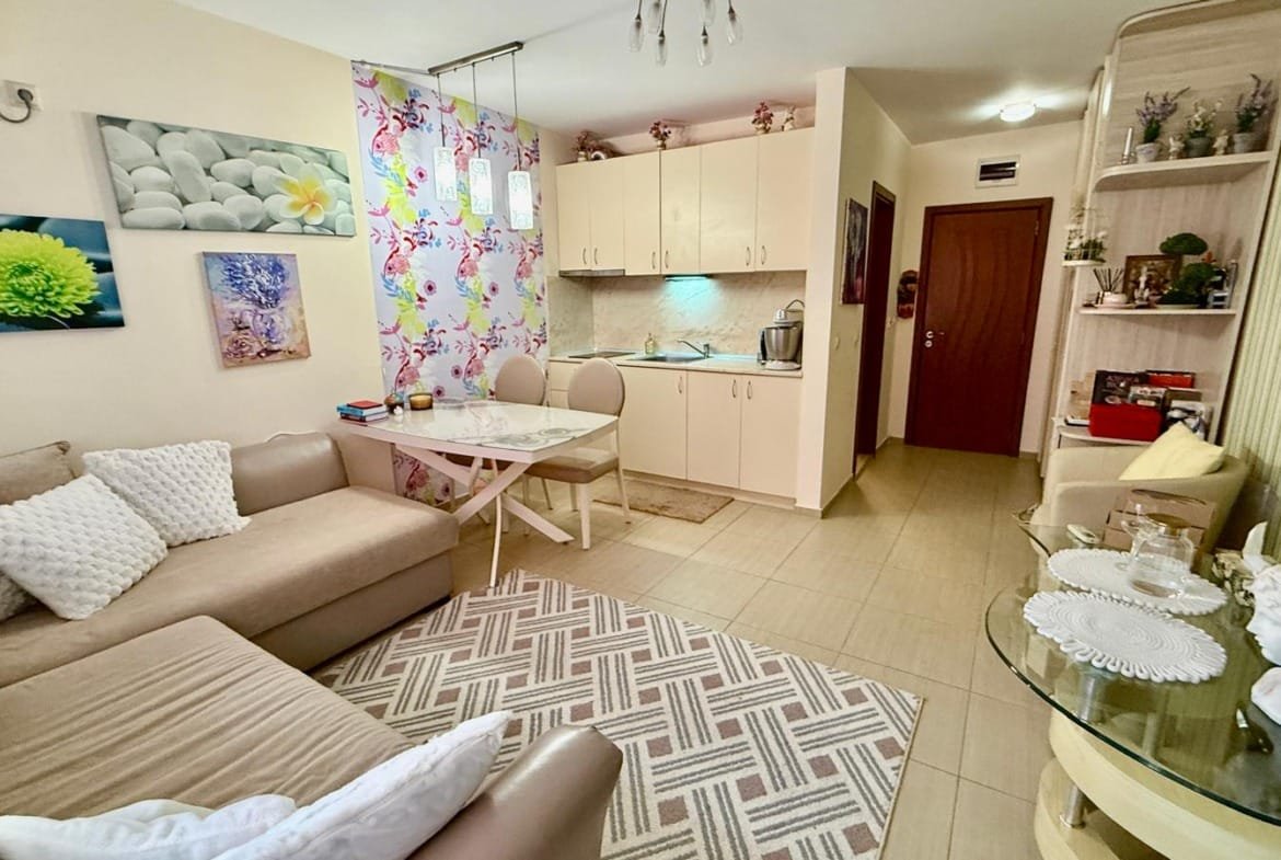 Современная уютная квартира в Болгарии с светлыми стенами, стильной мебелью и зоной для кухни и отдыха.