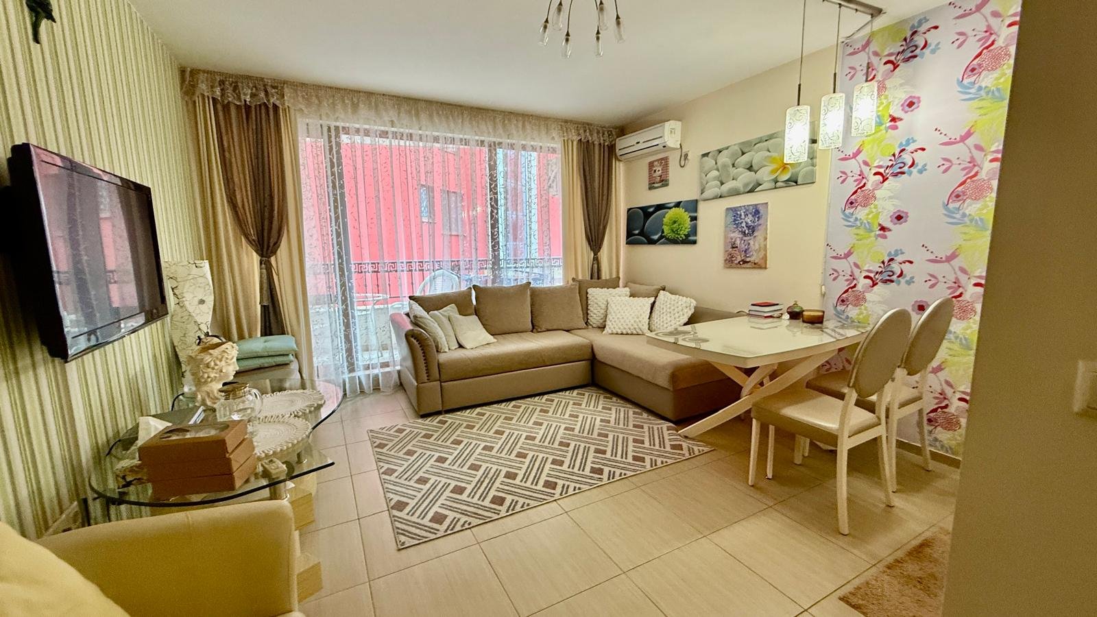 Современный уютный интерьер квартиры в Болгарии с мягкой мебелью, обеденной зоной и яркими акцентами на стенах.