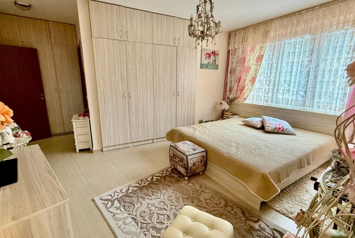 Современная спальня в Болгарии с светлыми тонами, уютной кроватью и стильной мебелью, идеальная для жизни или сдачи в аренду.