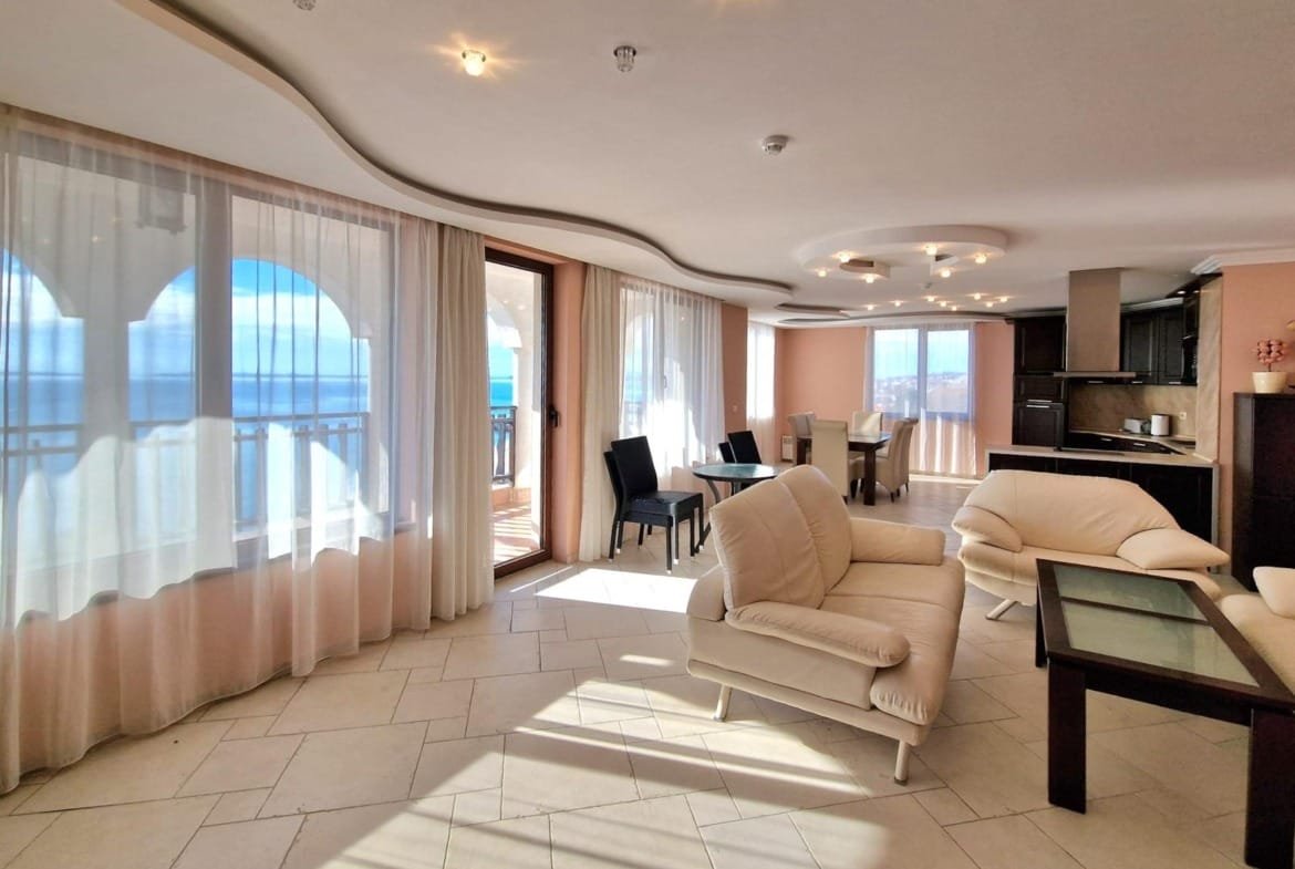 Современная квартира с панорамным видом на море, светлыми стенами и стильной мебелью в Болгарии. Подходит для покупки и аренды.