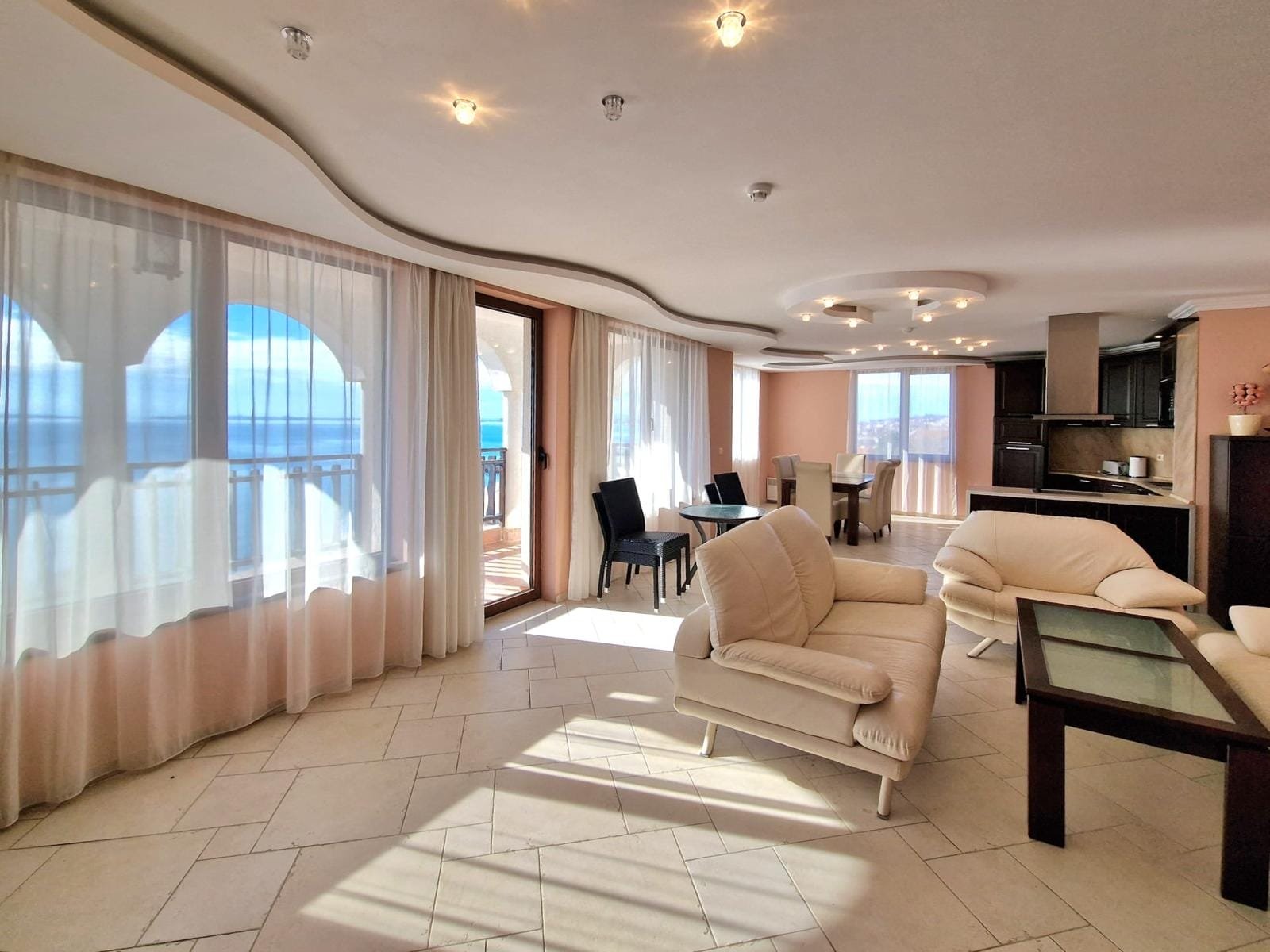 Современная квартира с панорамным видом на море, светлыми стенами и стильной мебелью в Болгарии. Подходит для покупки и аренды.