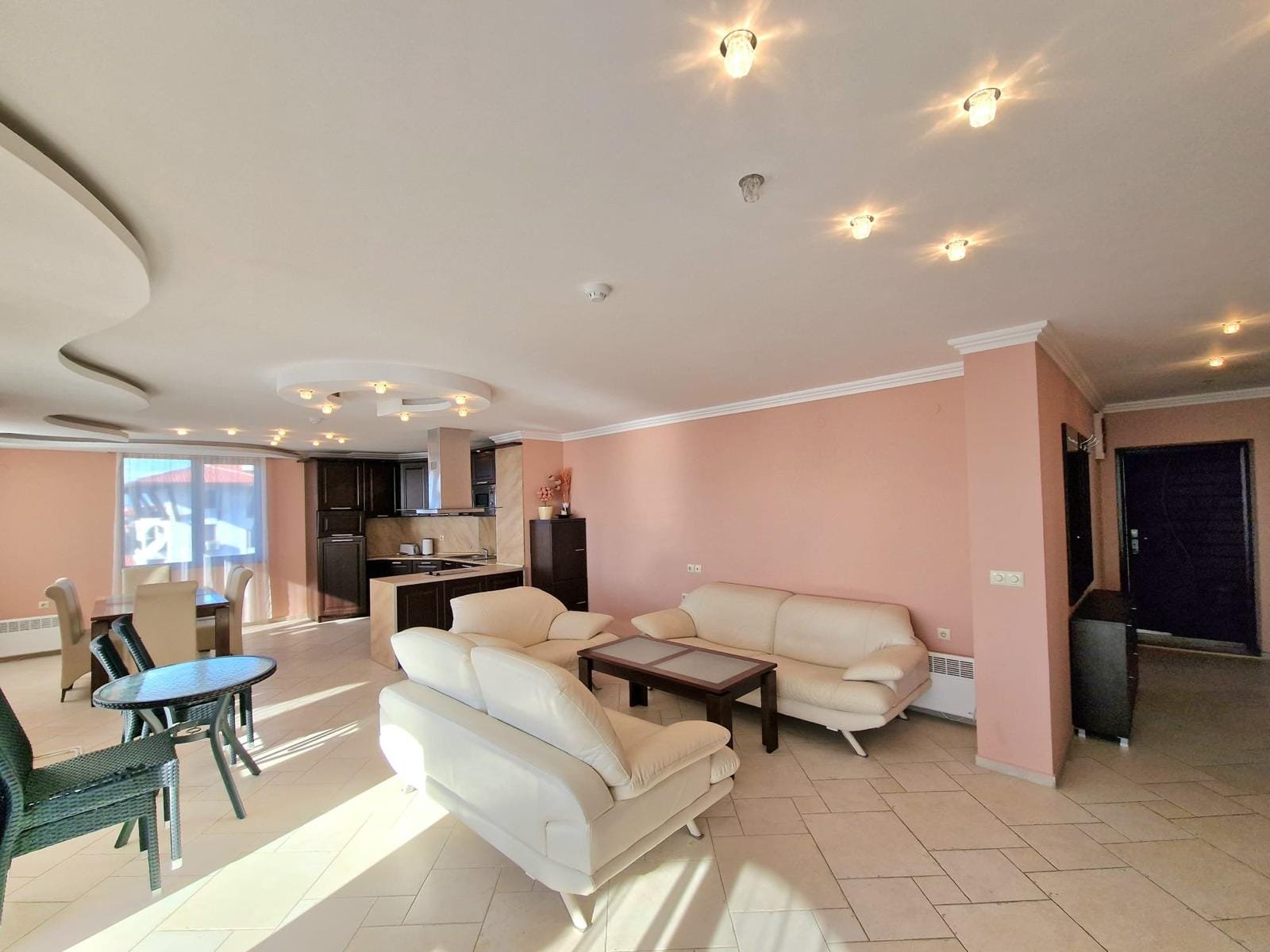 Современный интерьер квартиры в Болгарии с мягкой мебелью, кухней и обильным естественным светом. Уютное место для жизни.