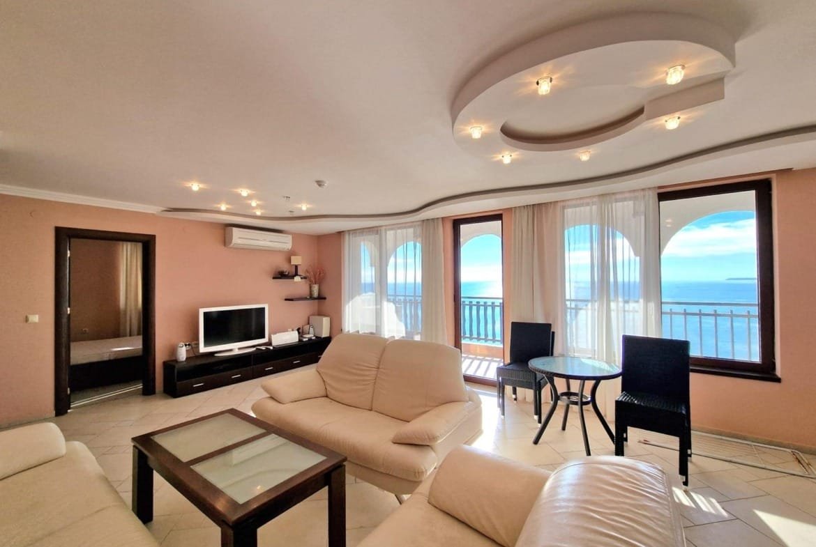 Современная гостиная с панорамными окнами, мебелью и видом на море, идеальное пространство для отдыха в Болгарии.