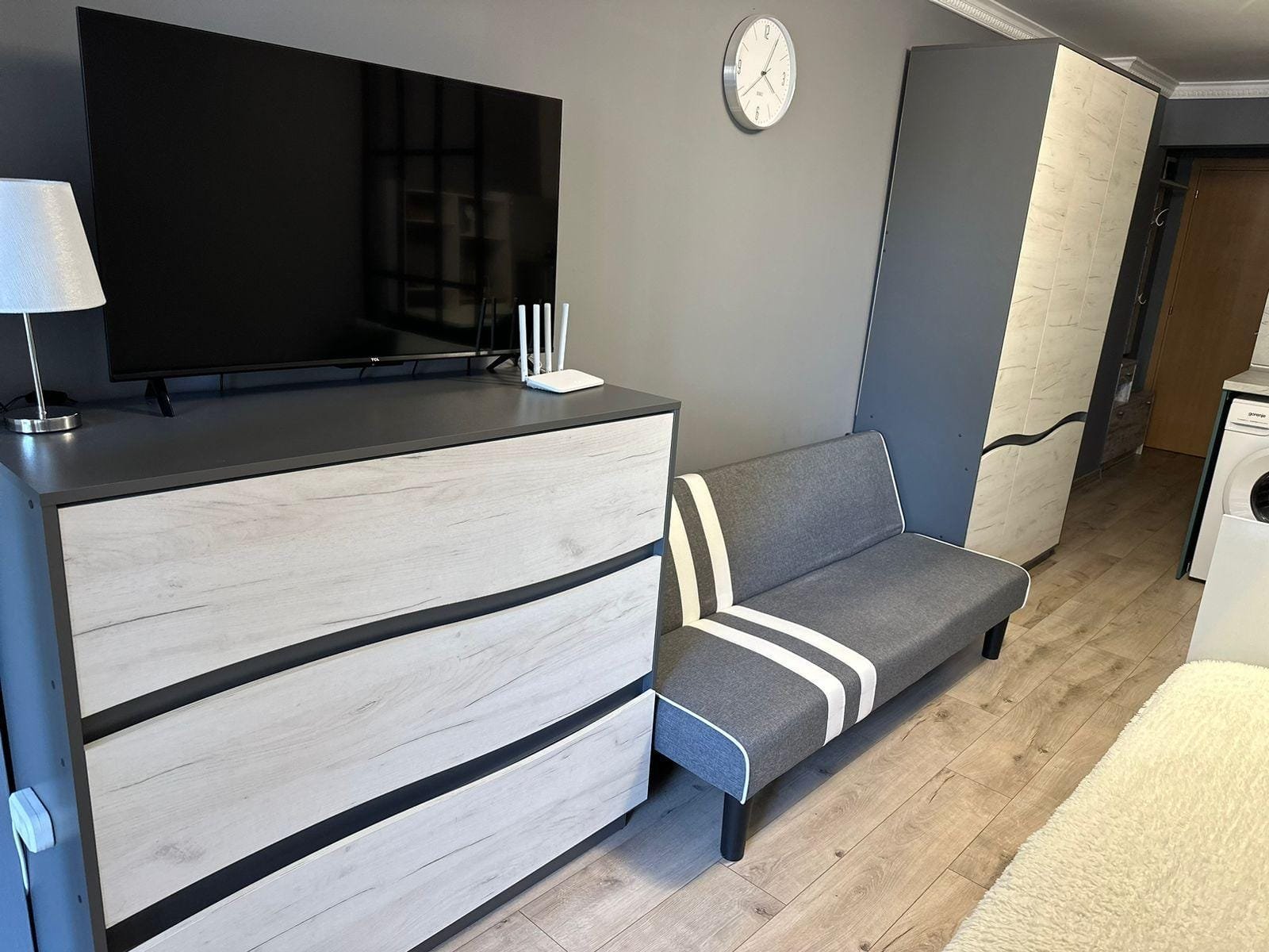 Современный интерьер квартиры в Болгарии с телевизором, диваном и шкафом, создающий уютное пространство для жизни или аренды.