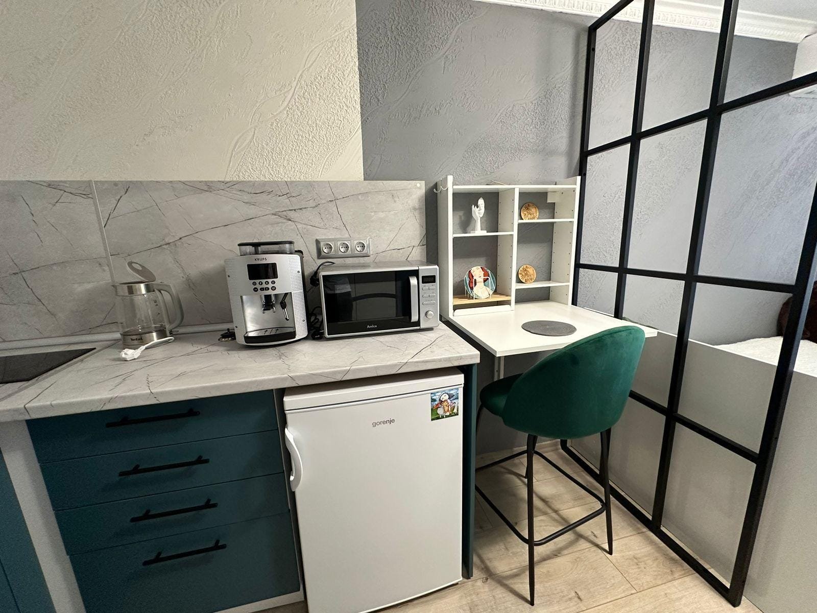 Современная кухня с техникой, столом для работы и зелёным стулом, идеальна для комфортного проживания в Болгарии.