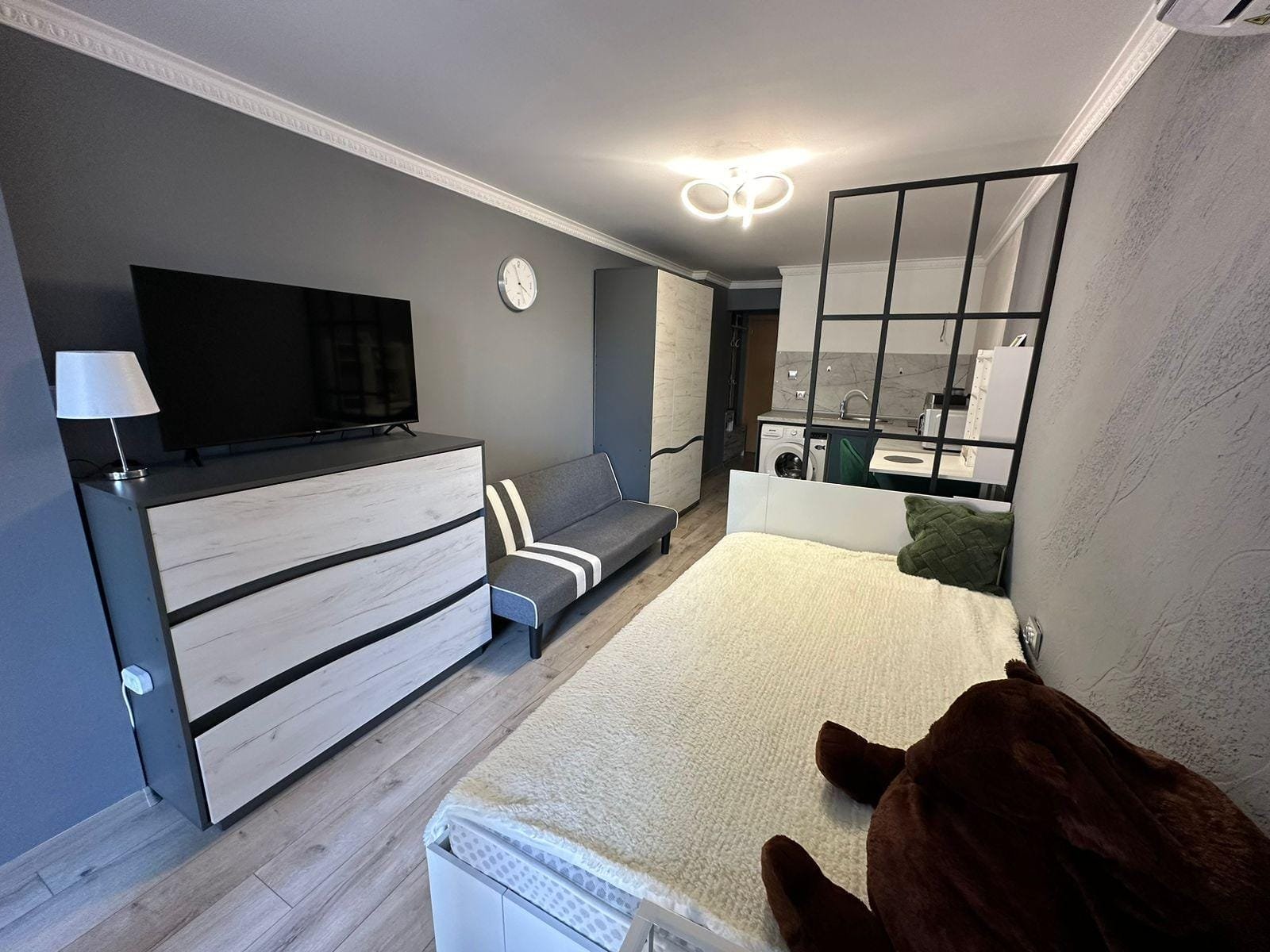 Современно оформленная квартира в Болгарии с телевизором, диваном и кухней, идеально подходит для покупки или аренды.